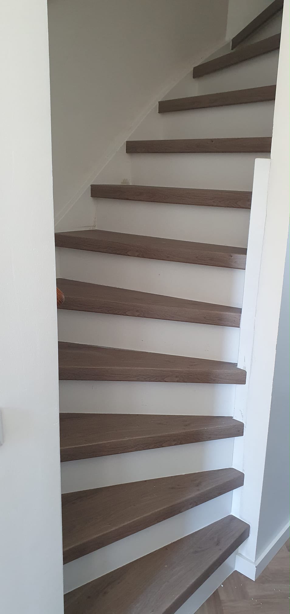 Close-up van traptreden met houtlook en zwarte trapprofielen