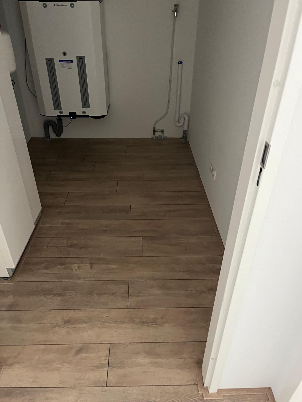 Ruimte met een bruine vloer met houtlook en een deur