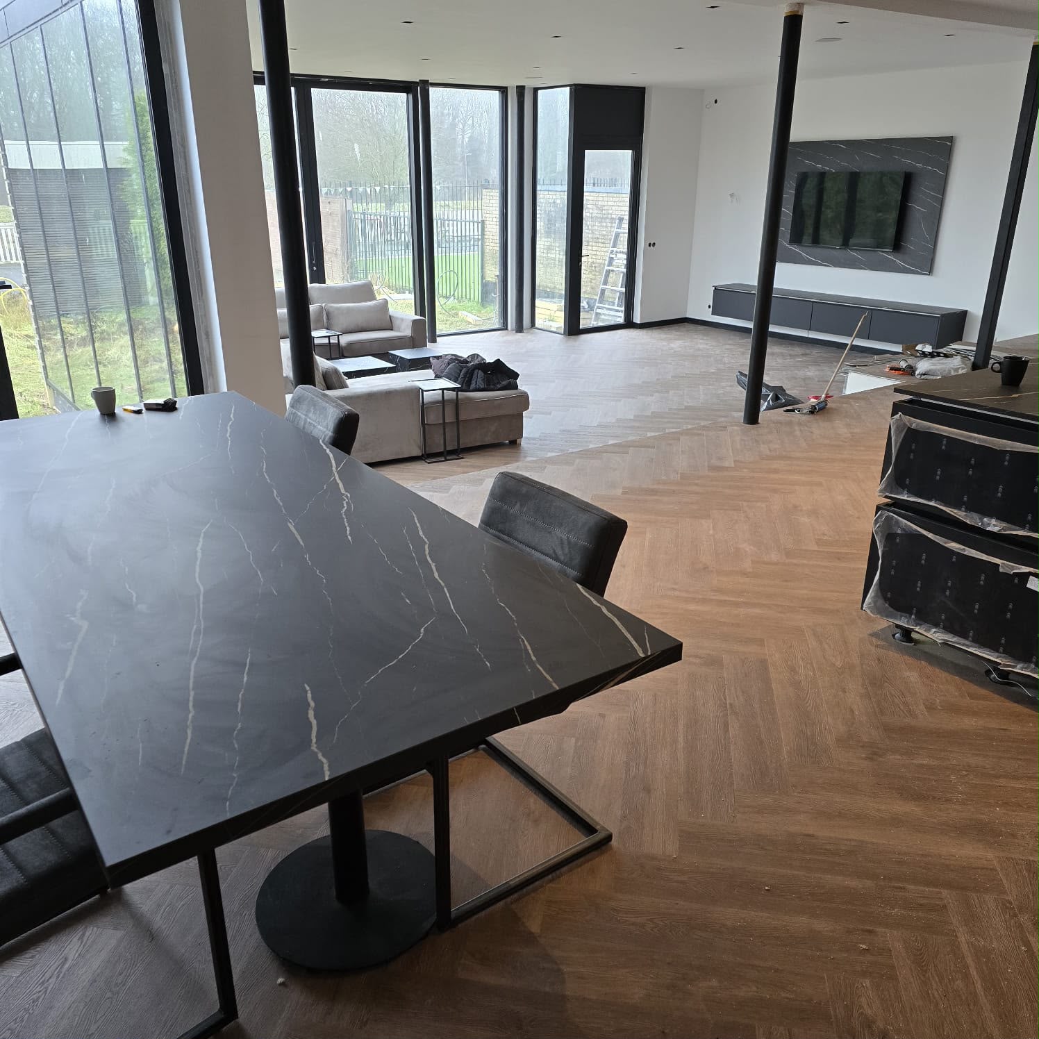 Woonkamer met een vloer in visgraatpatroon en een eettafel